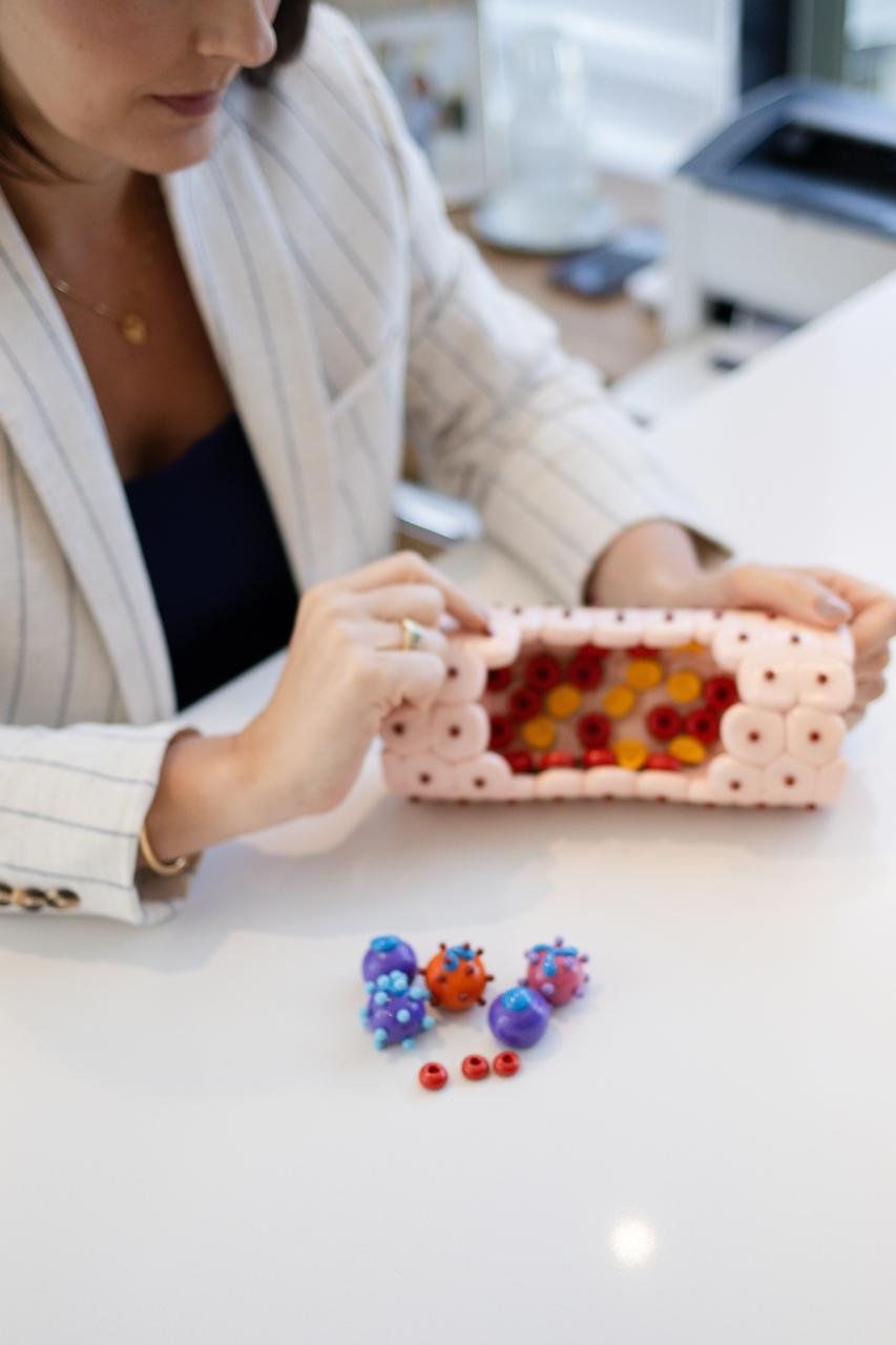 Dra. Andrezza Medina com um modelo didático de vaso sanguíneo
